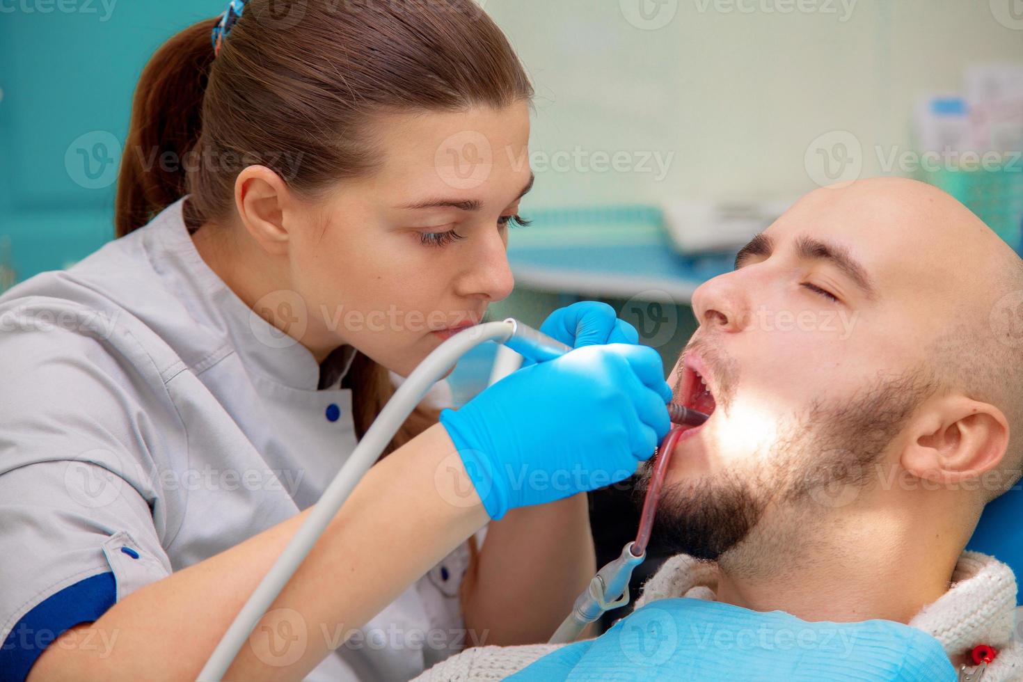 Dentist curing a male patient photo