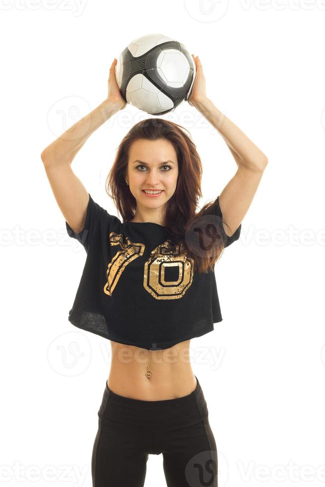 Vertical portrait of young cheerful girl with soccer ball in hands smiling on camera photo