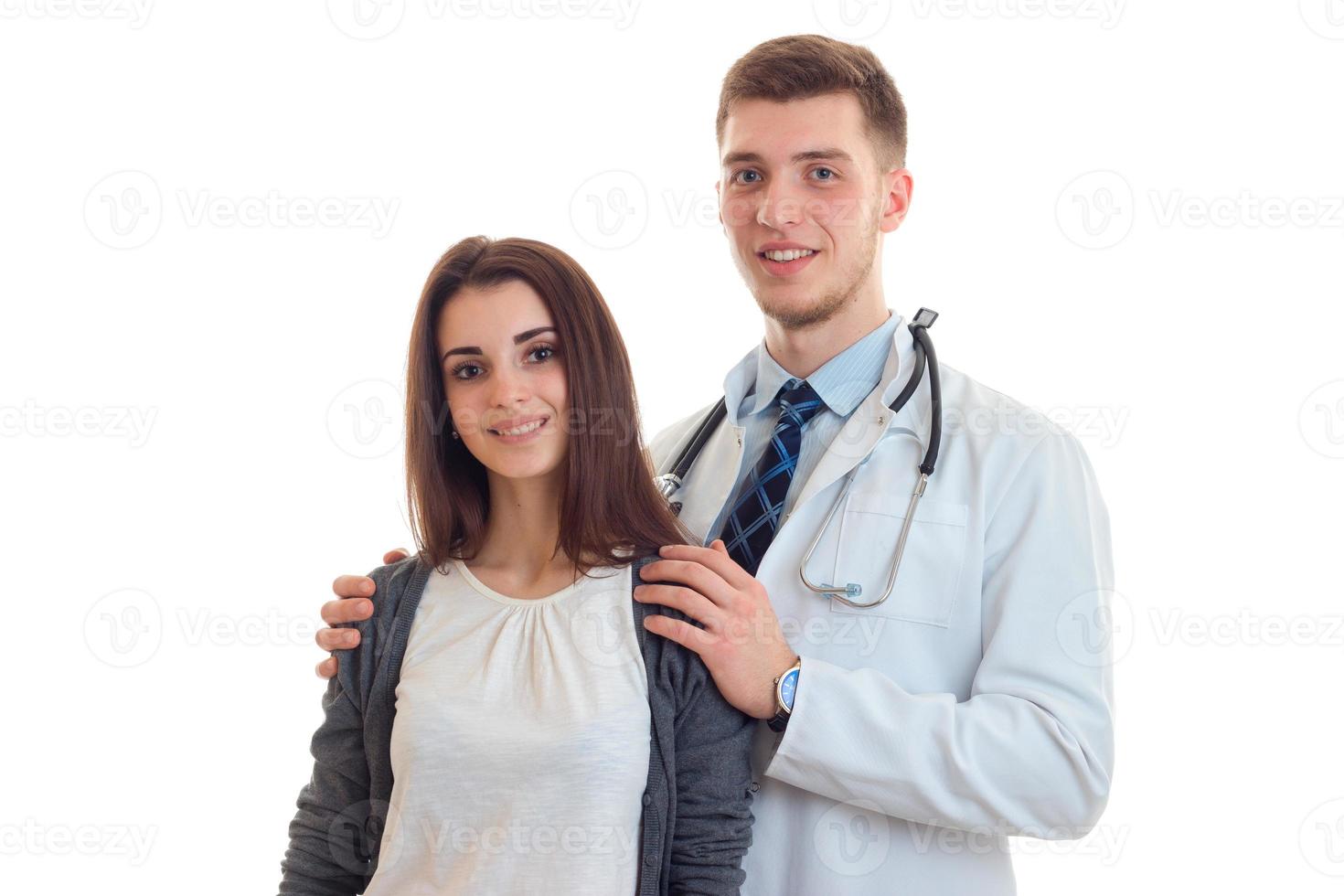 Cheerful young doctor hugging his patient and smiling photo