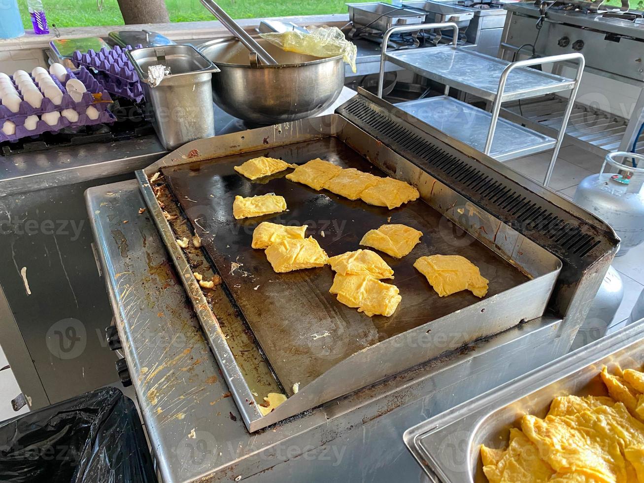 un montón de huevos revueltos, huevos revueltos en la estufa en el restaurante de cocina abierta en el hotel todo incluido en un complejo turístico paradisíaco de vacaciones en un país tropical cálido foto