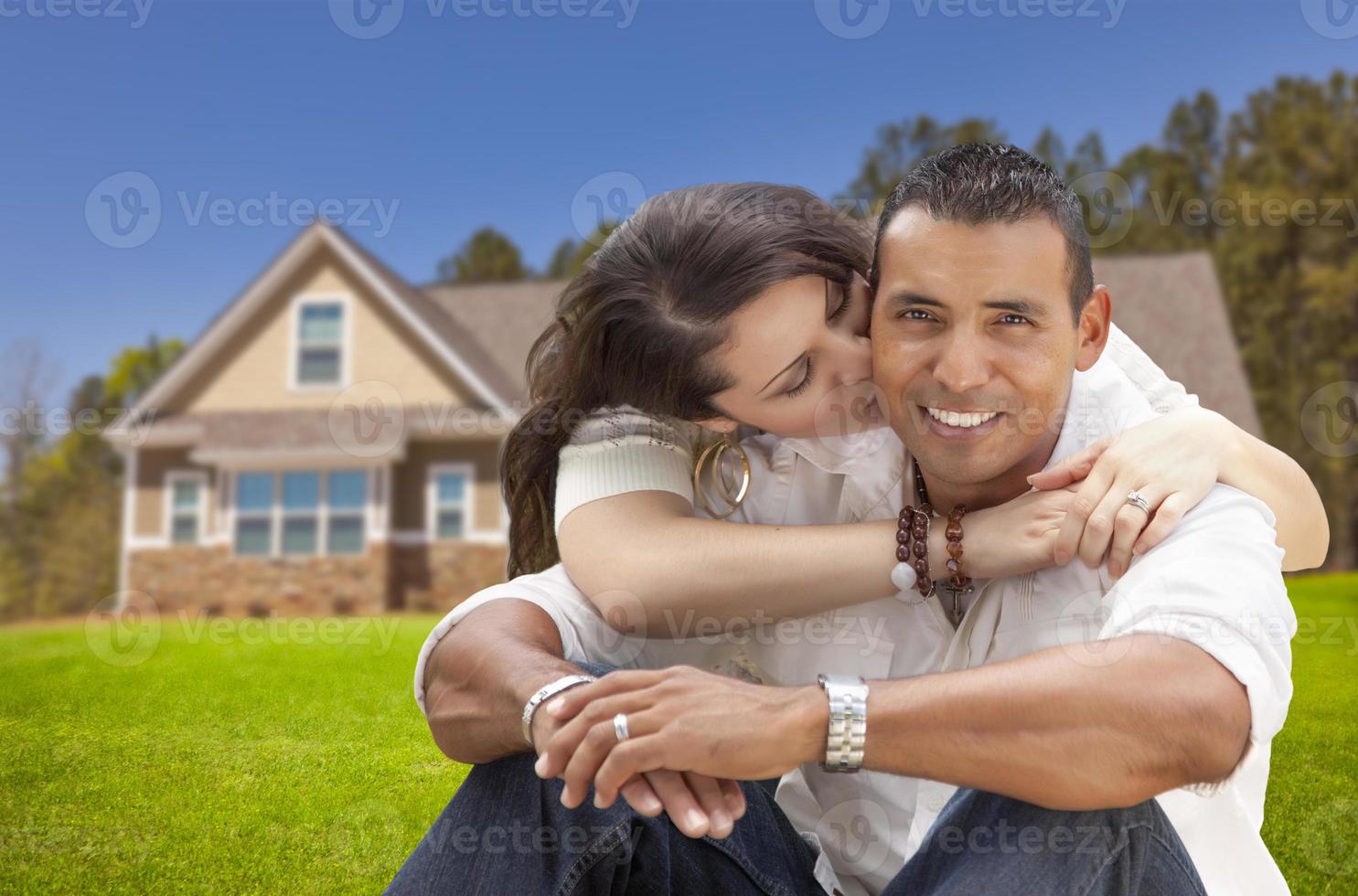 Happy Hispanic Young Couple in Front of Their New Home photo
