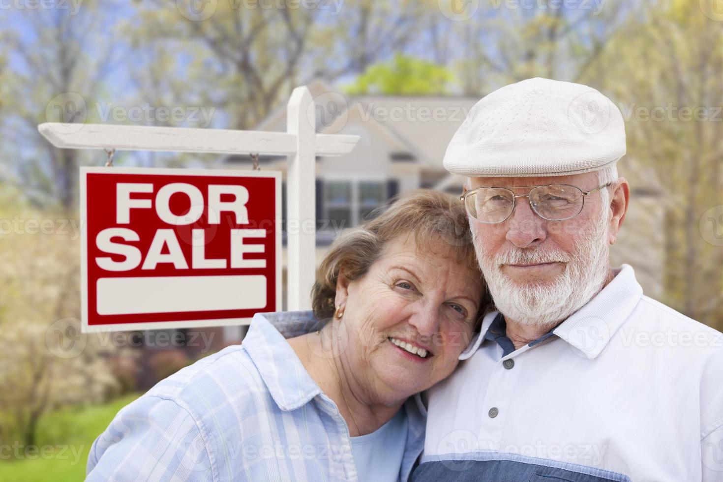 Happy Senior Couple Front of For Sale Sign and House photo