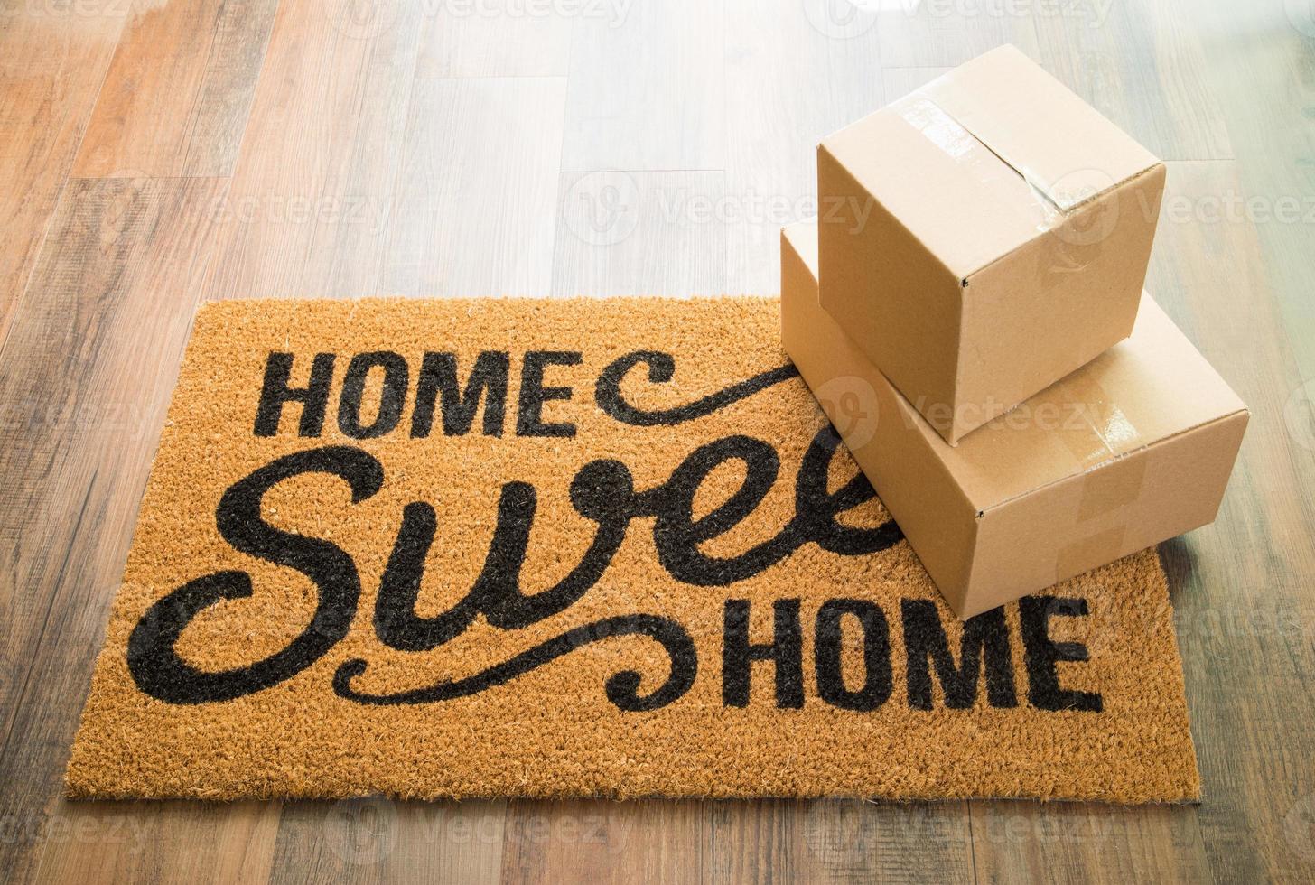 Home Sweet Home Welcome Mat On Wood Floor With Boxes photo