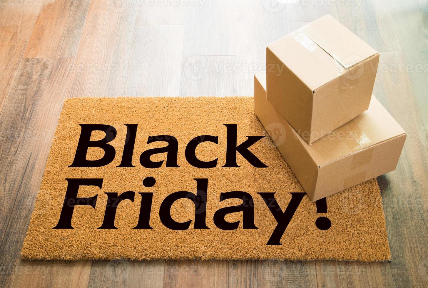 Black Friday Welcome Mat On Wood Floor With Shipment of Boxes photo