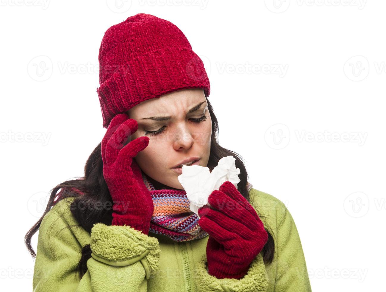 mujer de raza mixta enferma que sopla su nariz dolorida con un pañuelo foto