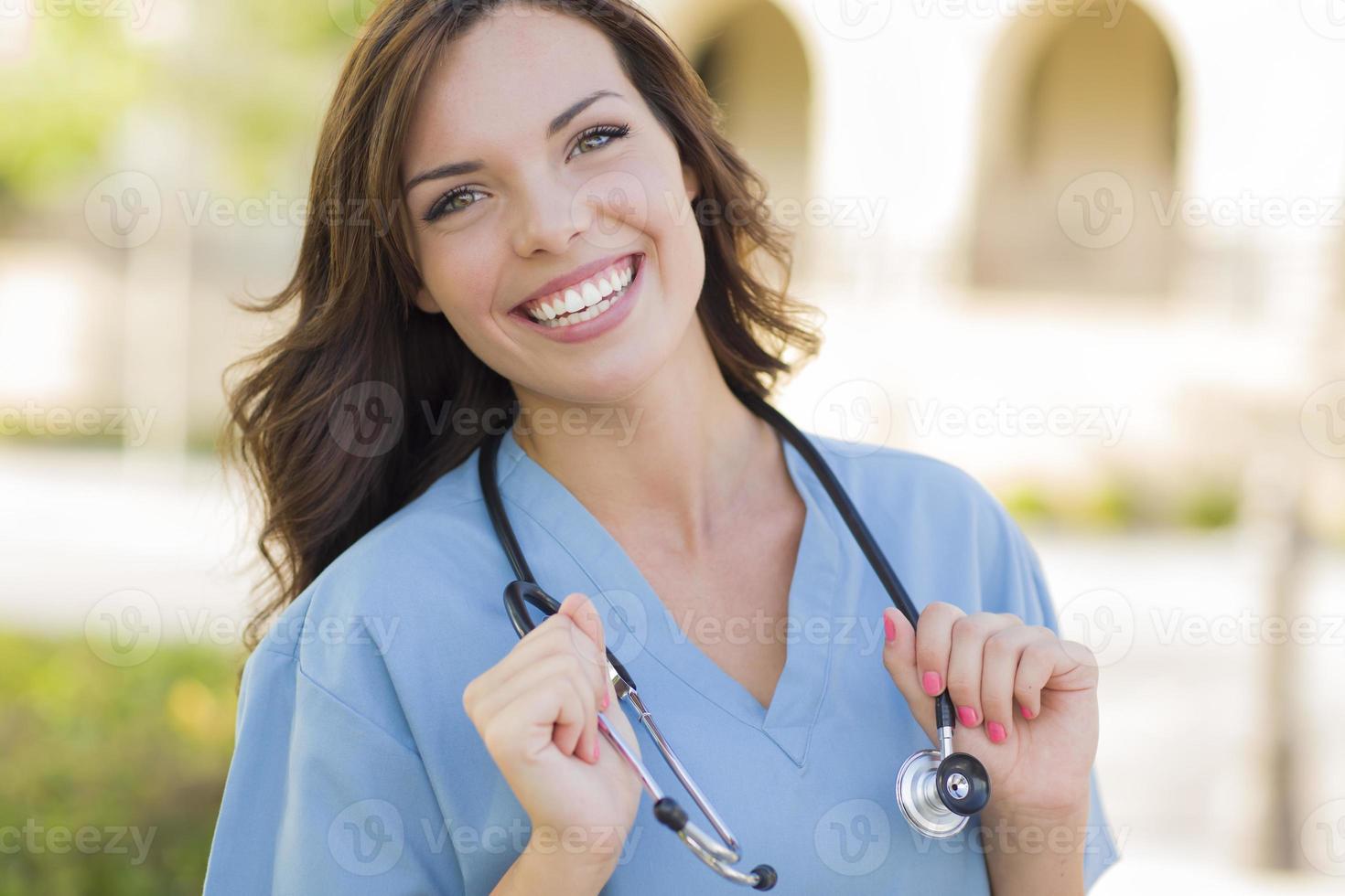 Retrato de médico o enfermera de mujer adulta joven fuera foto