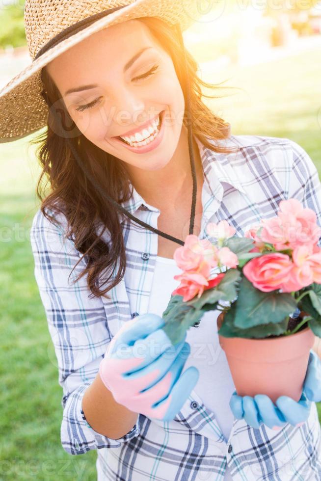 mujer adulta joven con sombrero y guantes de jardinería al aire libre foto