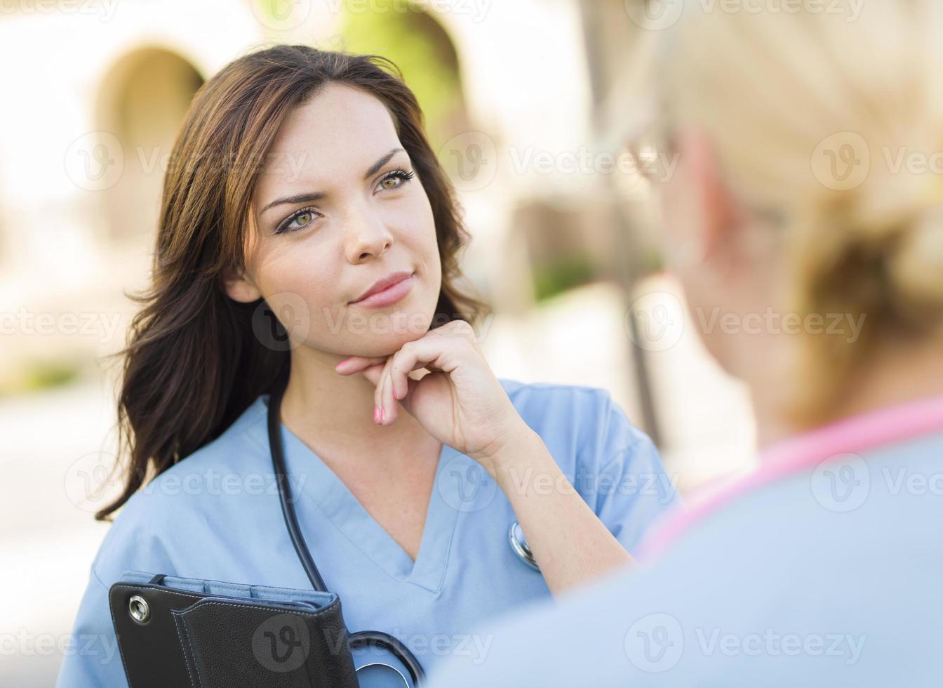 Two Young Adult Female Doctors or Nurses Talking Outside photo