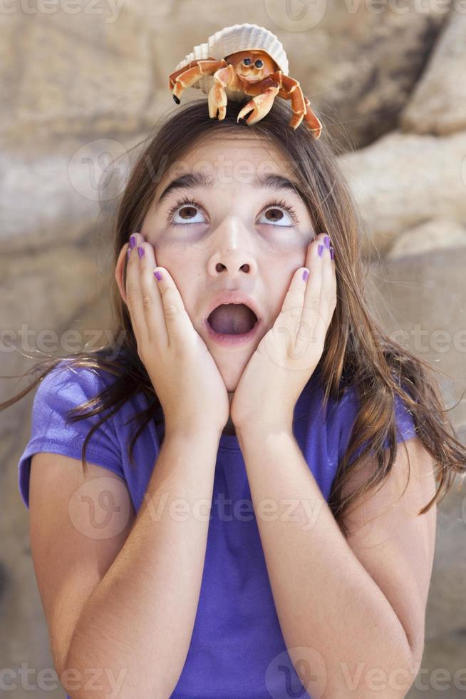 Niña jugando con cangrejo ermitaño de juguete foto