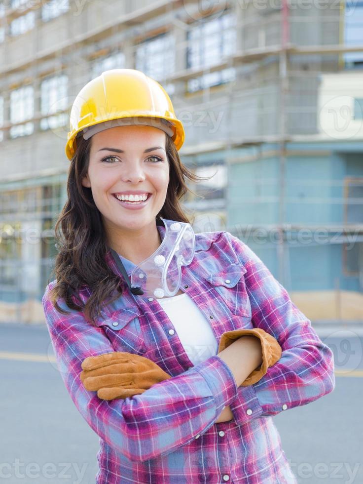 Young Attractive Female Construction Worker Wearing Hard Hat and Gloves photo