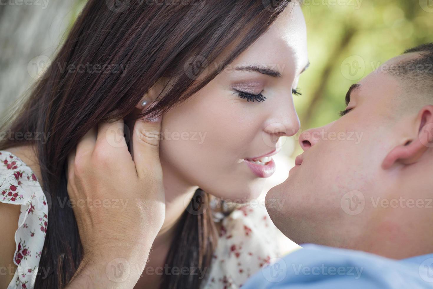 Mixed Race Romantic Couple Kissing in the Park photo