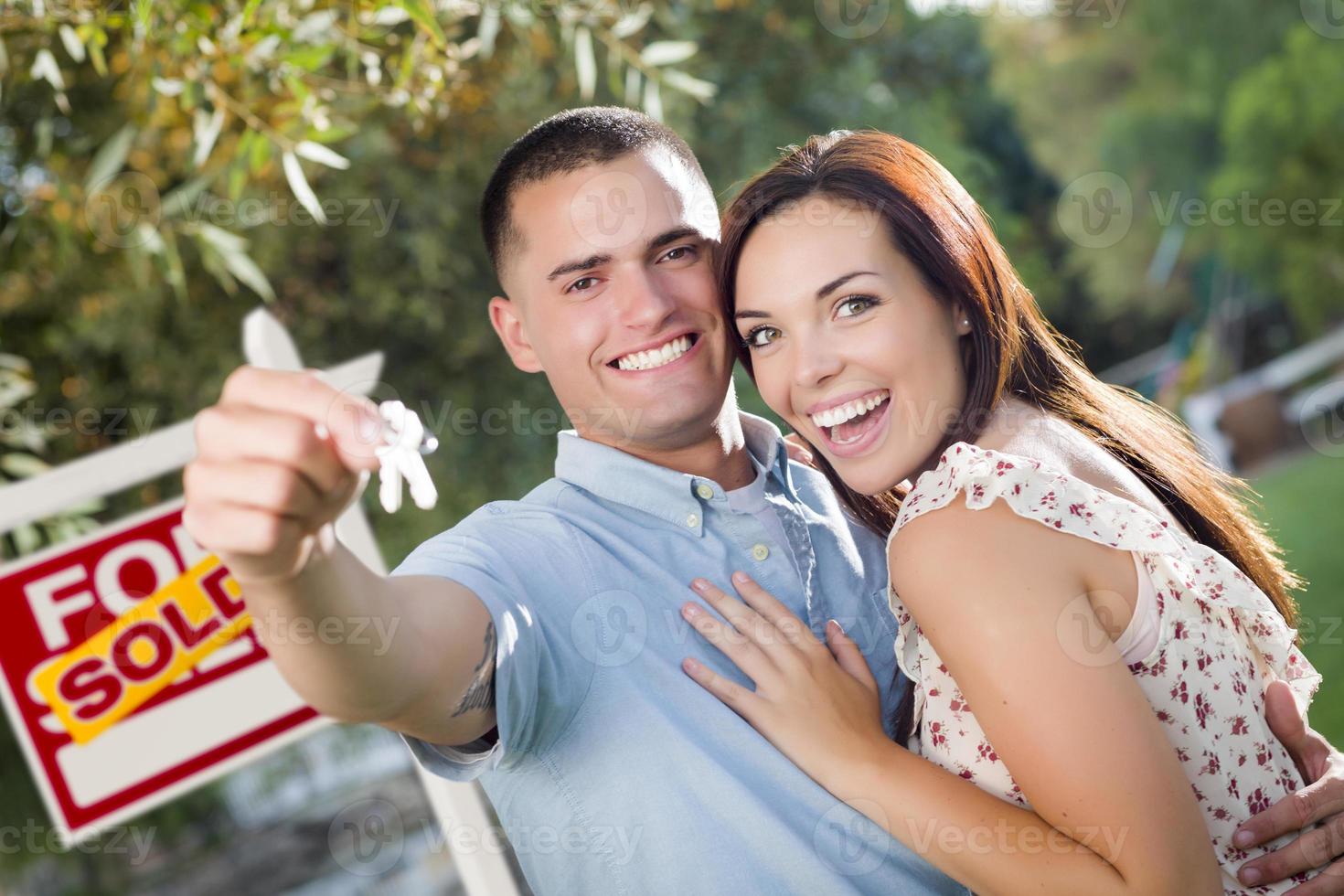 Military Couple with House Keys and Sold Real Estate Sign photo
