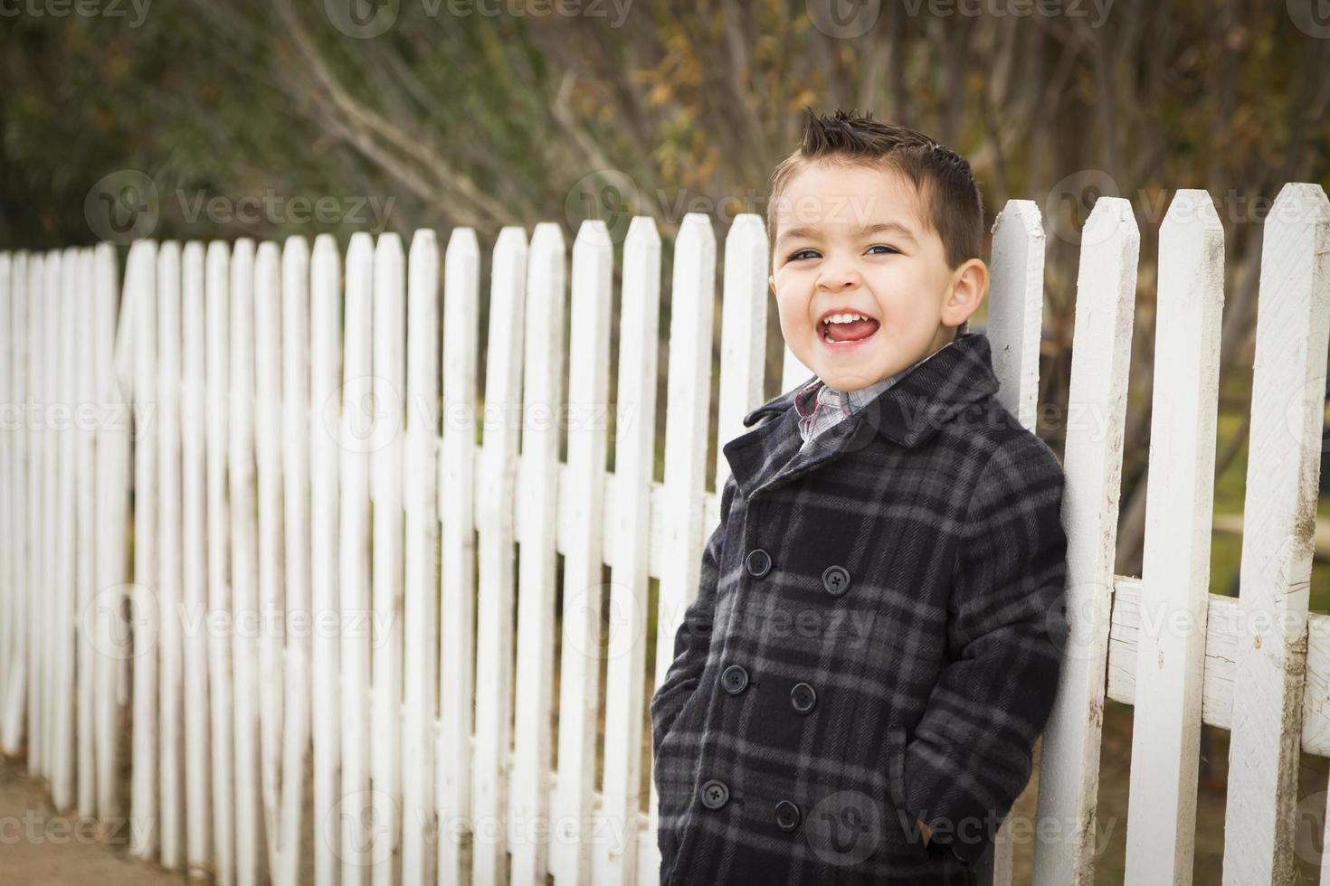 Young Mixed Race Boy Waiting For School Bus Along Fence photo