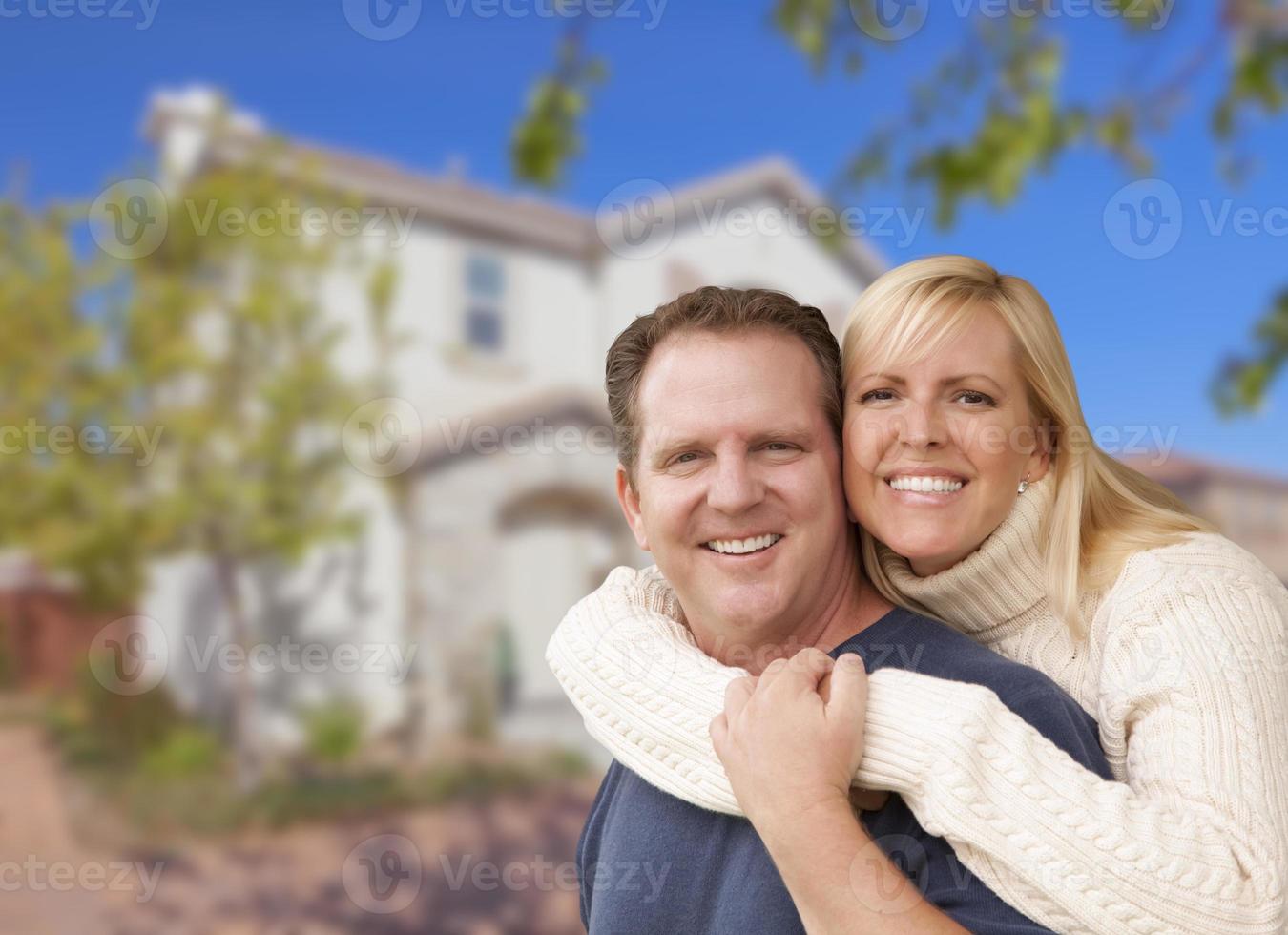 feliz pareja abrazándose frente a casa foto