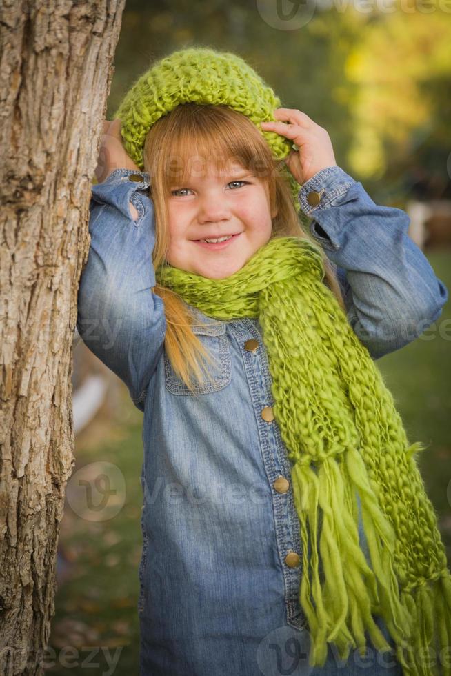 Portrait of Cute Young Girl Wearing Green Scarf and Hat photo