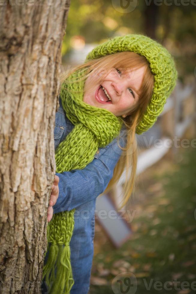 Portrait of Cute Young Girl Wearing Green Scarf and Hat photo
