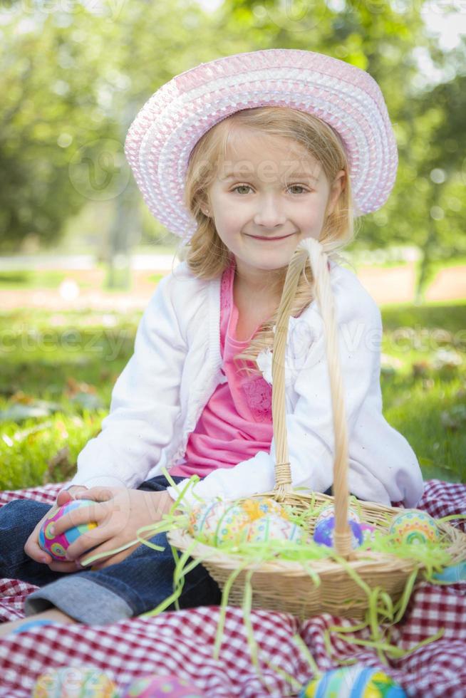 Cute Young Girl Wearing Hat Enjoys Her Easter Eggs photo