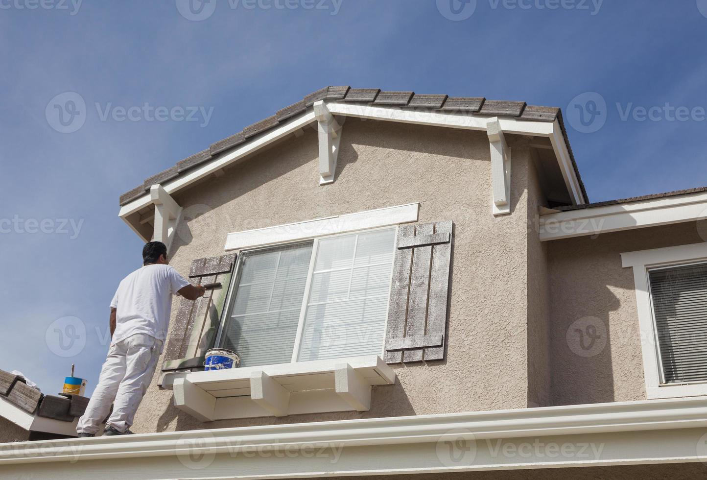 House Painter Painting the Trim And Shutters of Home photo