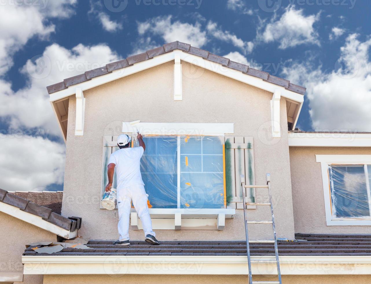 Professional House Painter Painting the Trim And Shutters of A Home. photo