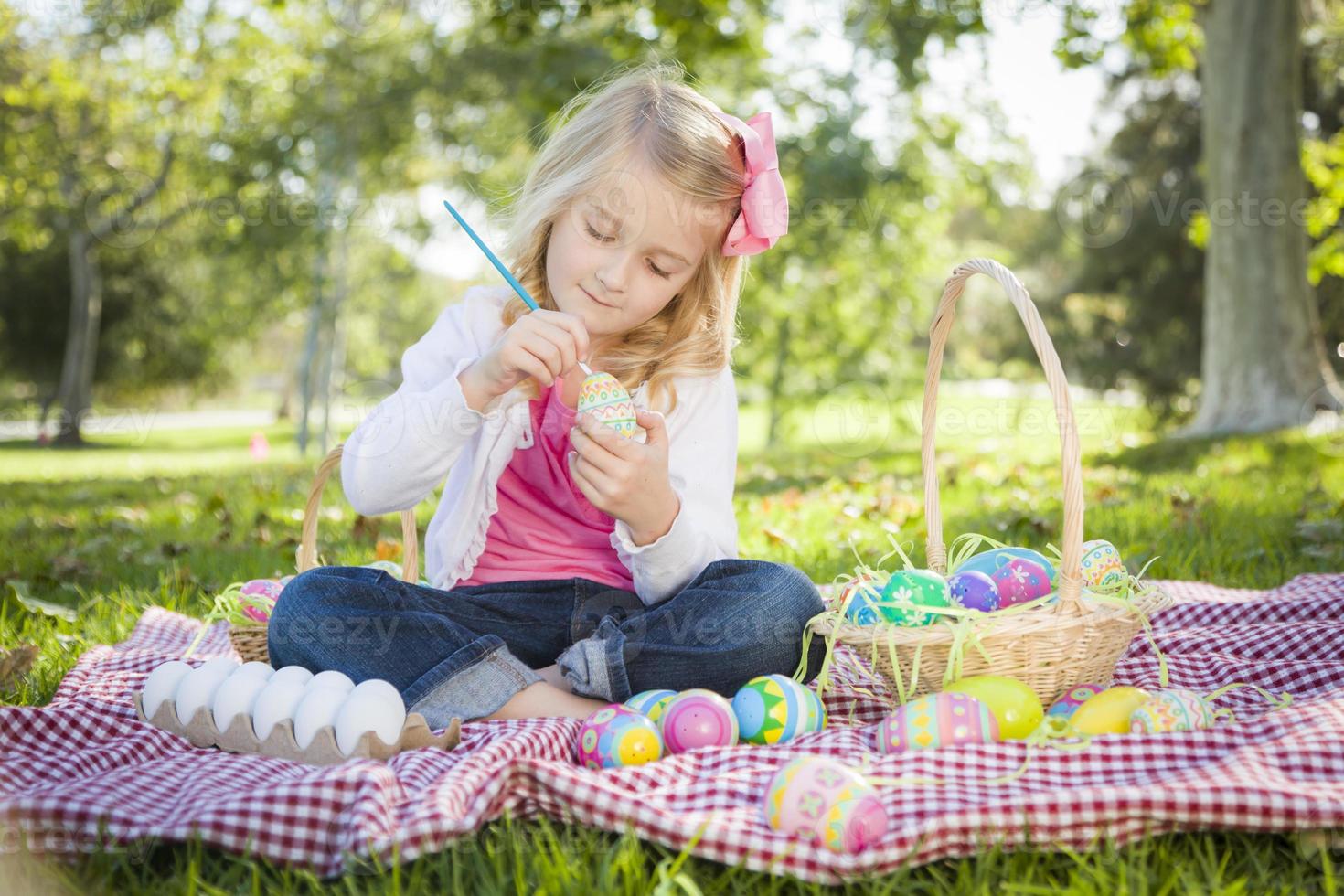 Cute Young Girl Coloring Her Easter Eggs with Paint Brush photo