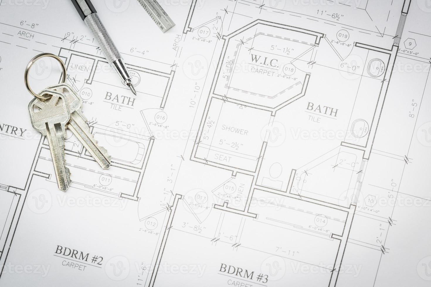 lápiz de ingeniero, regla y llaves que descansan sobre los planos de la casa foto