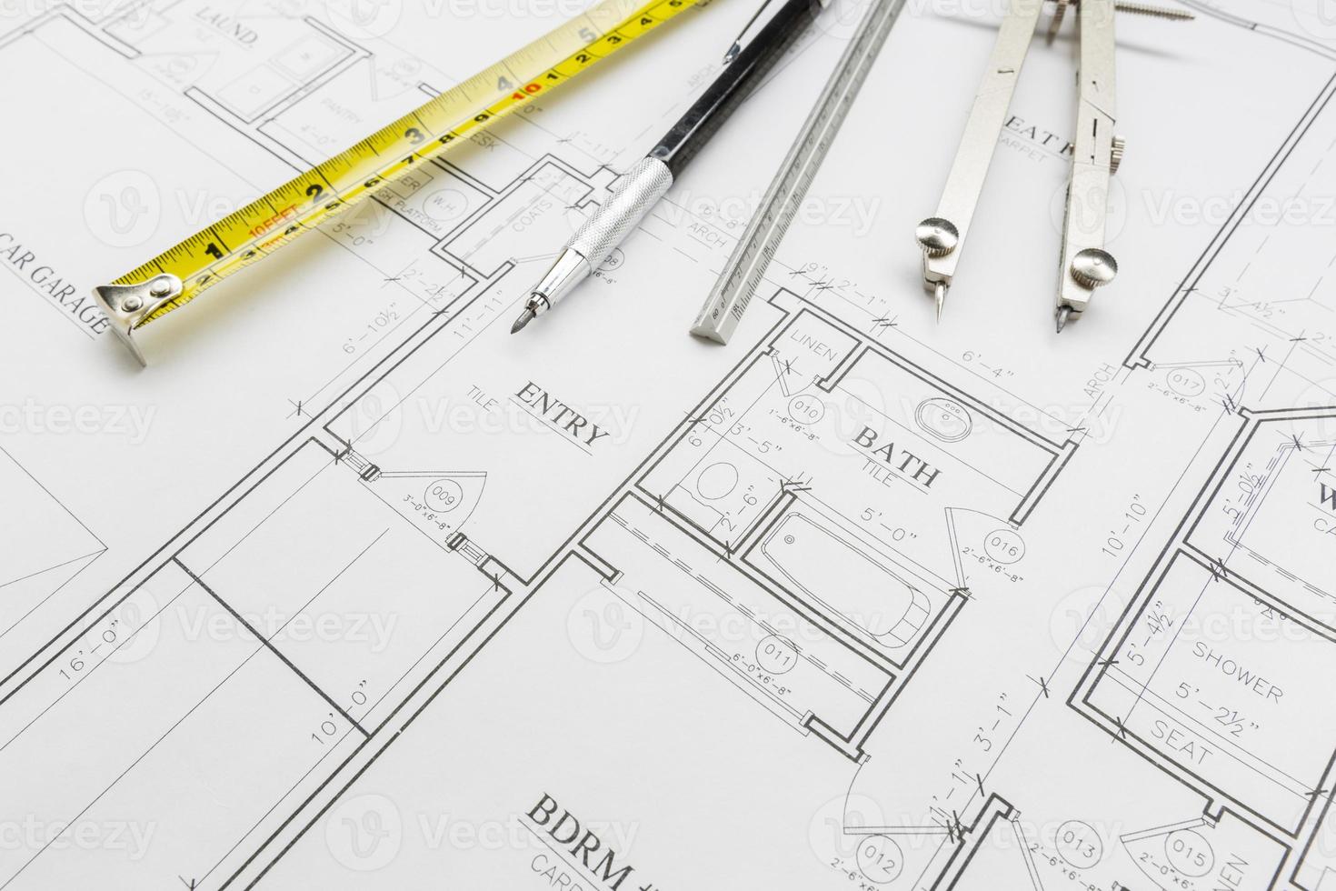 Measuring Tape, Pencil, Ruler and Compass Resting on House Plans photo