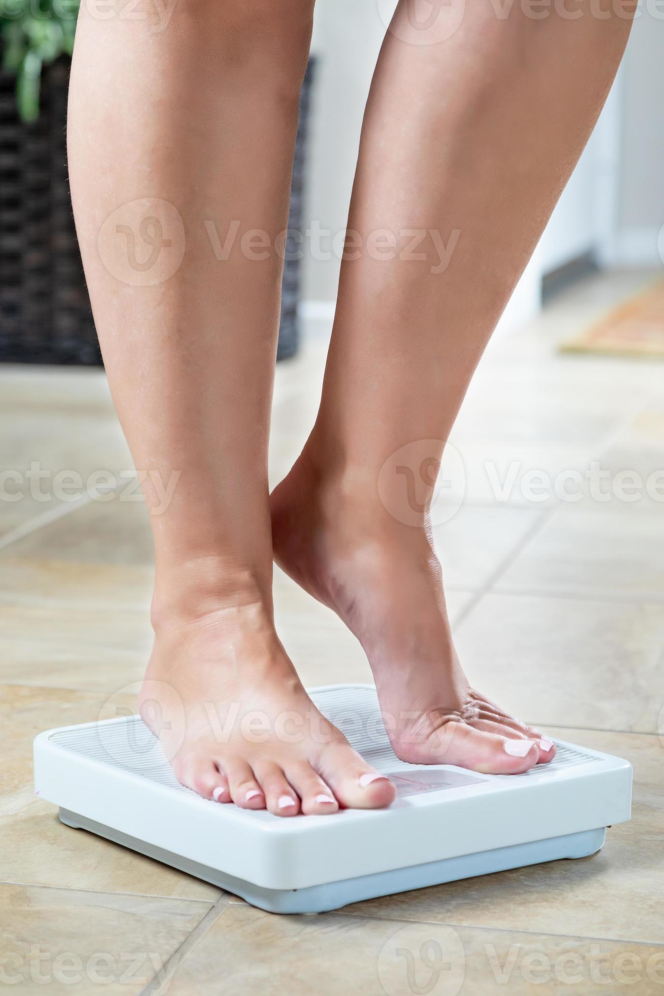Woman Standing on Weight Scale At Home 16418800 Stock Photo at Vecteezy