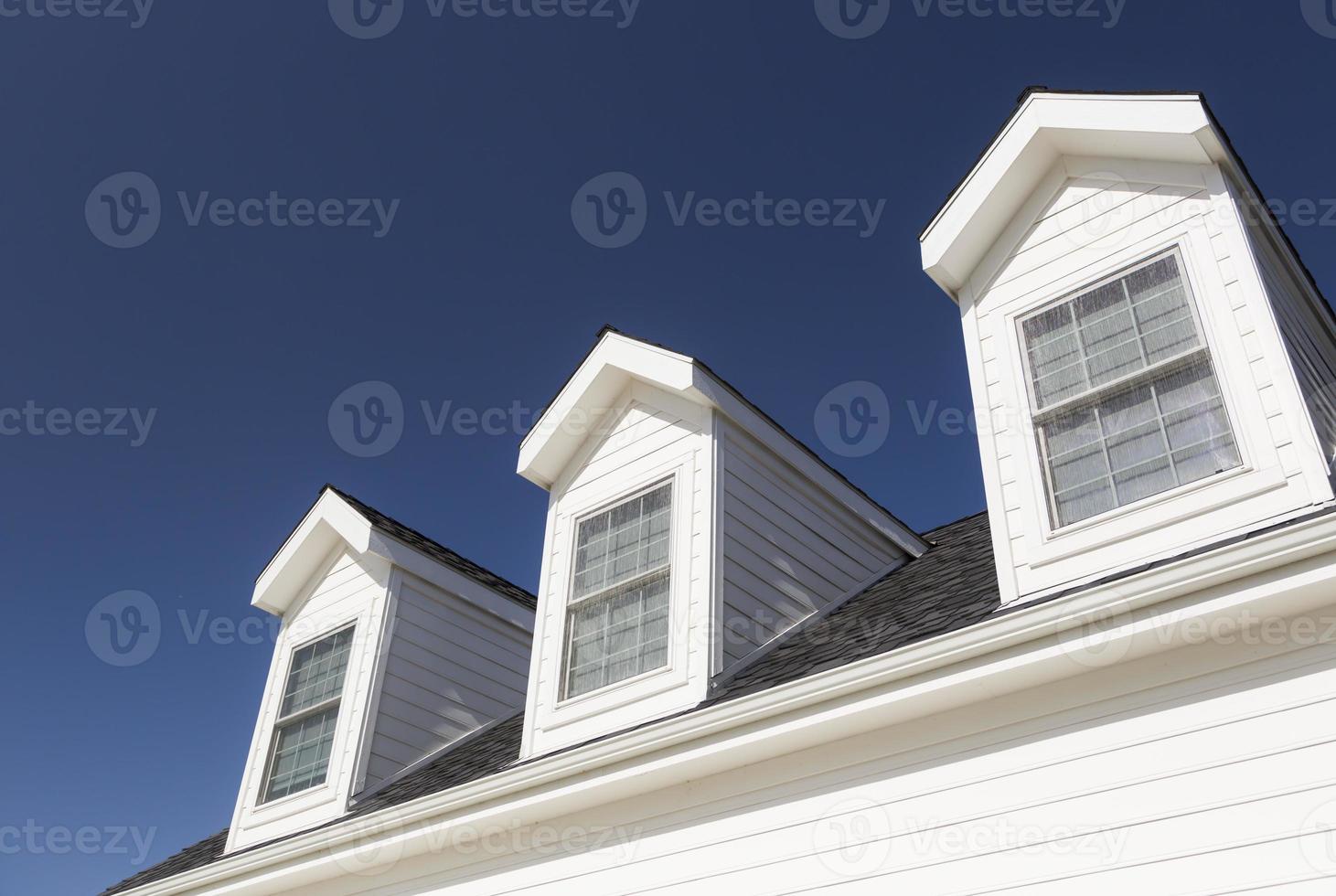 Roof of House and Windows Against Deep Blue Sky photo