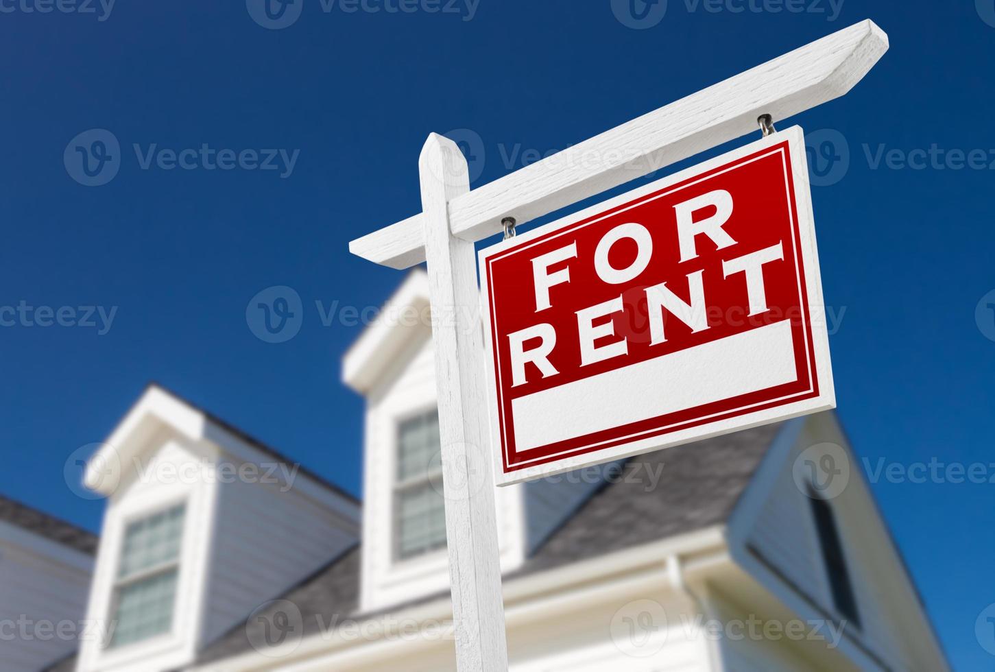 Right Facing For Rent Real Estate Sign In Front of House and Deep Blue Sky. photo