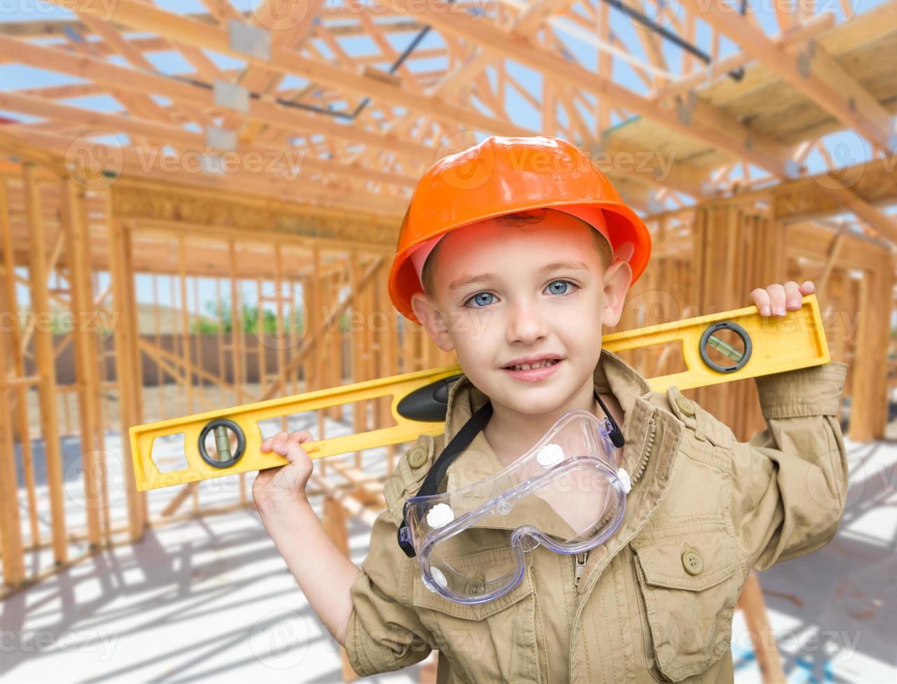 contratista joven con nivel en el sitio dentro del nuevo marco de construcción de viviendas. foto