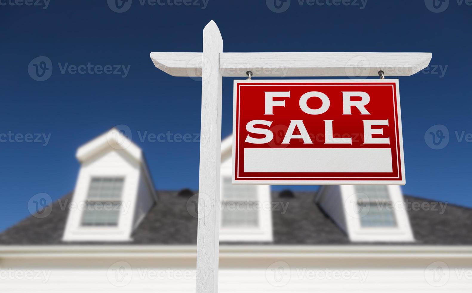 Right Facing For Sale Real Estate Sign In Front of House and Deep Blue Sky. photo