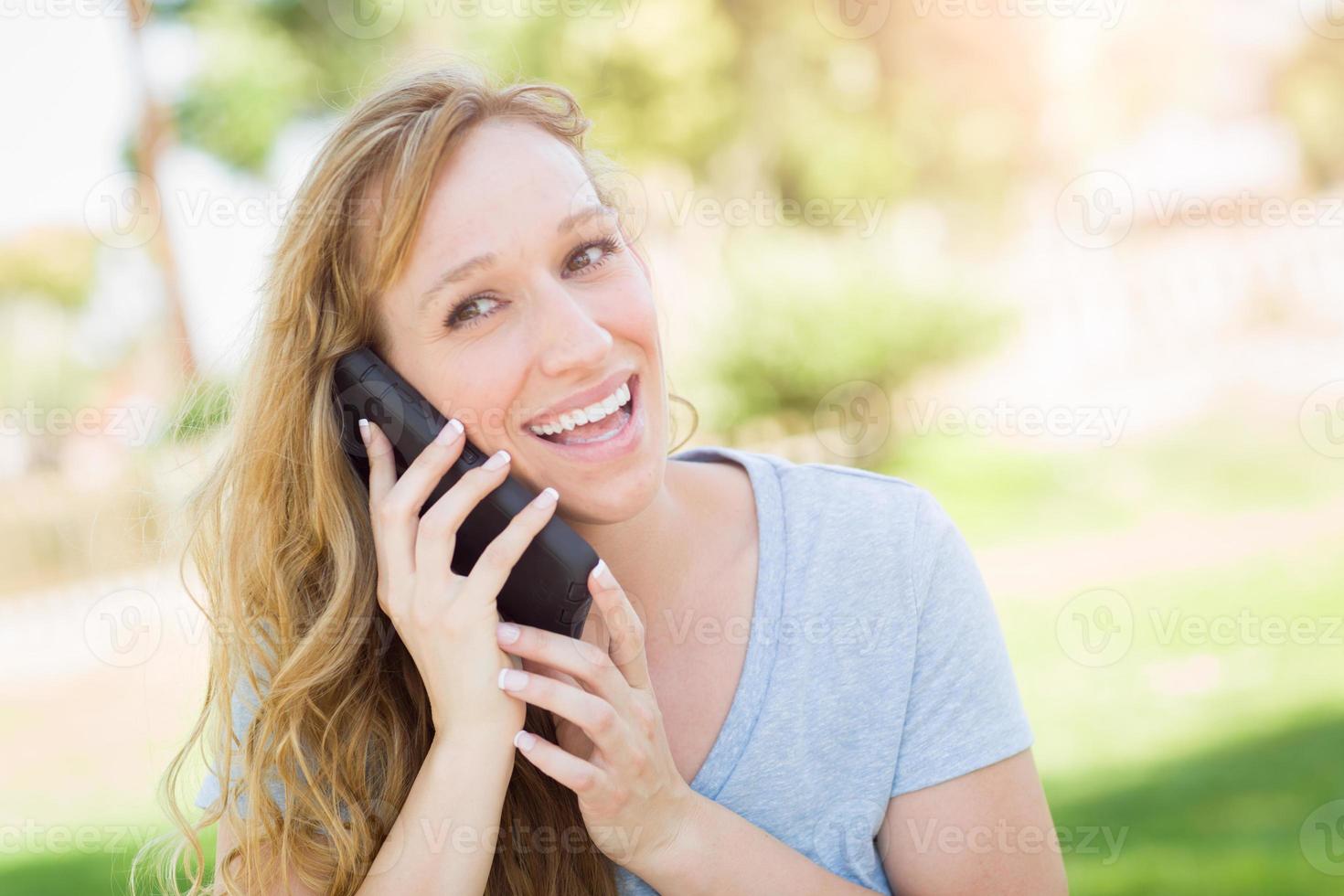 Young Adult Woman Outdoors Talking on Her Smart Phone. photo