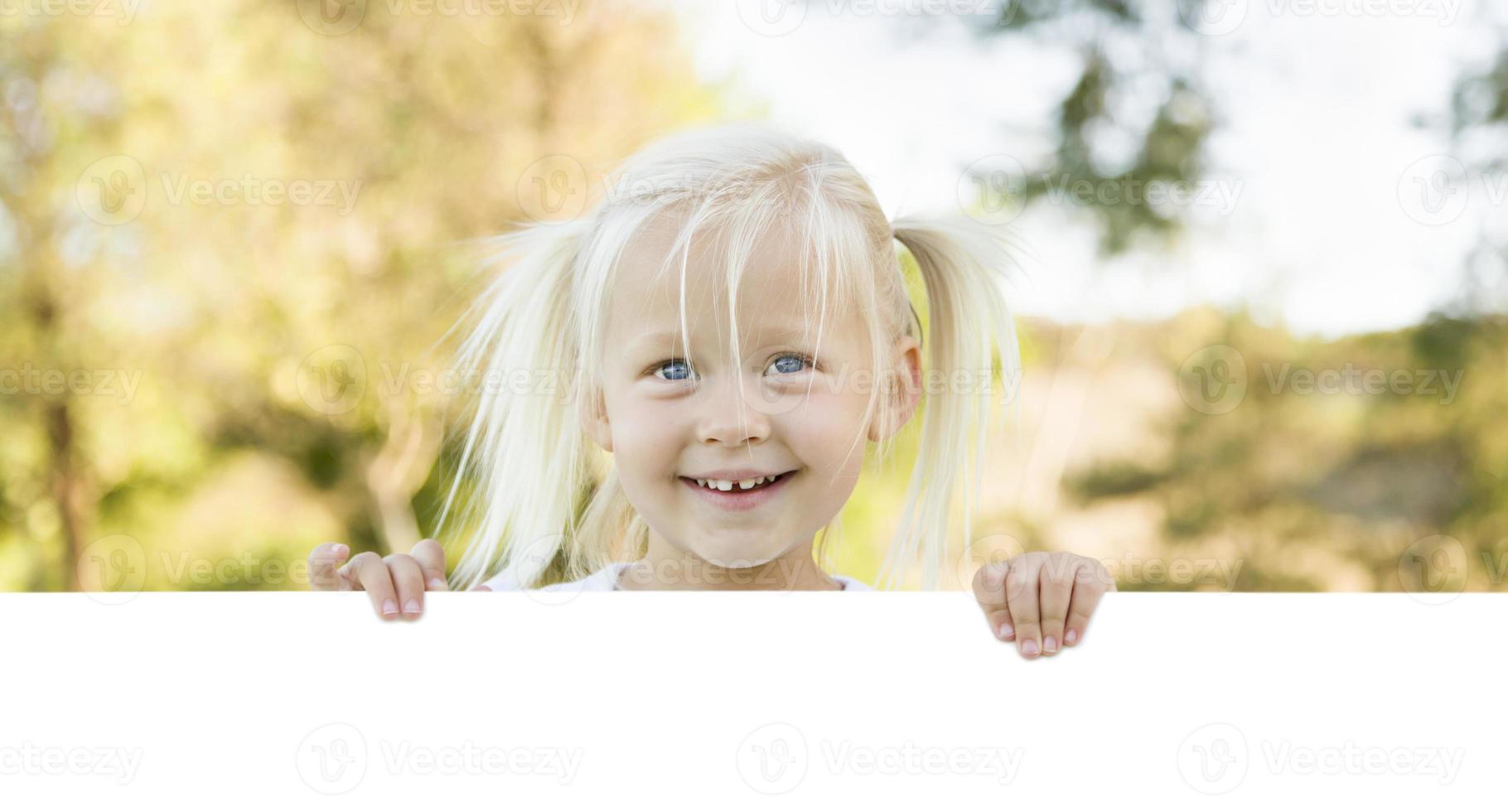 linda niña sosteniendo una pizarra blanca con espacio para texto foto