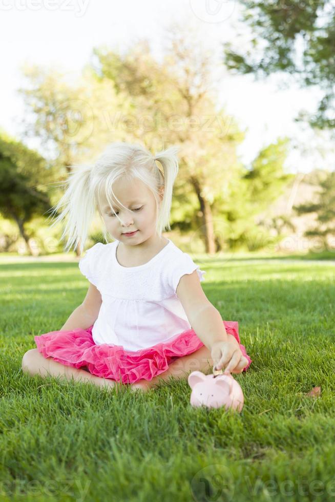 Little Girl Having Fun with Her Piggy Bank Outside photo