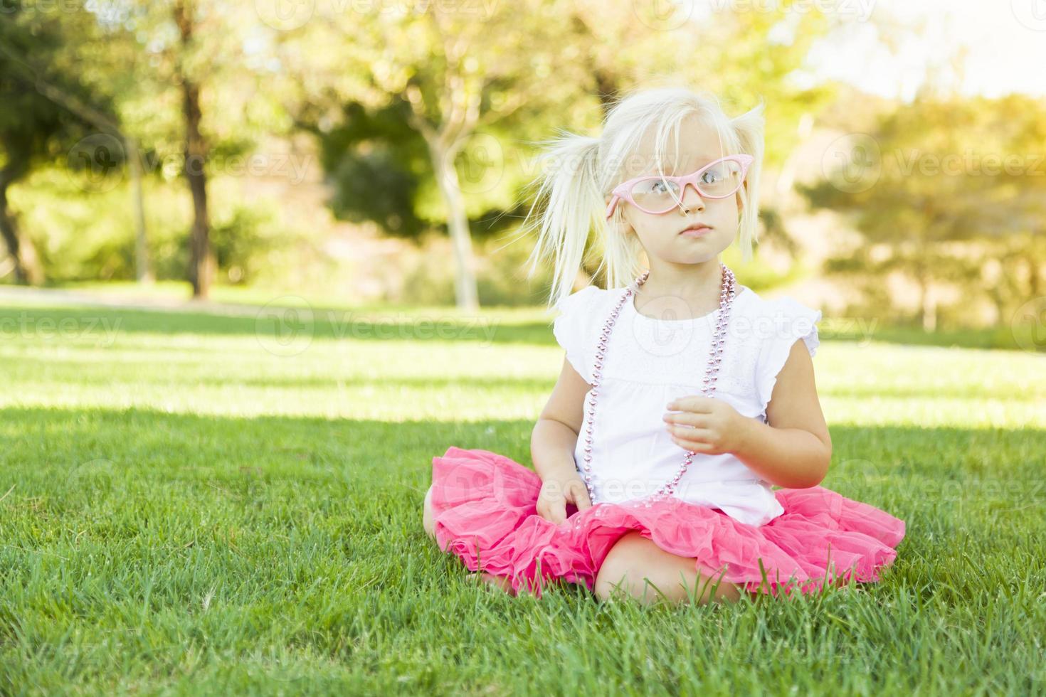 Little Girl Playing Dress Up With Pink Glasses and Necklace photo