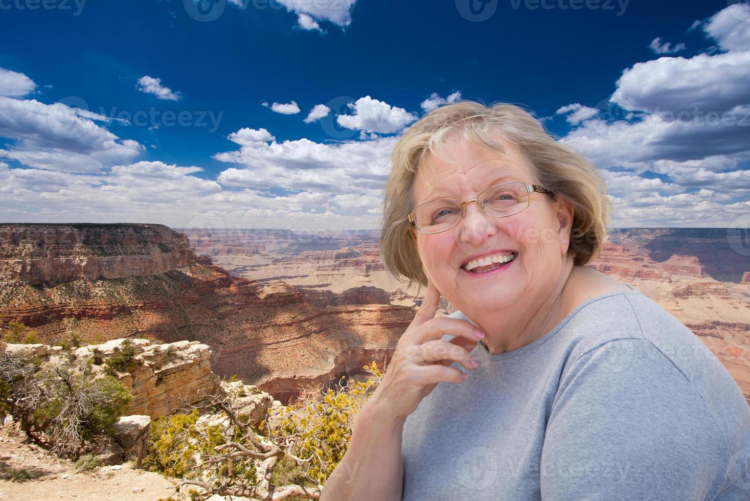 feliz anciana posando al borde del gran cañón foto