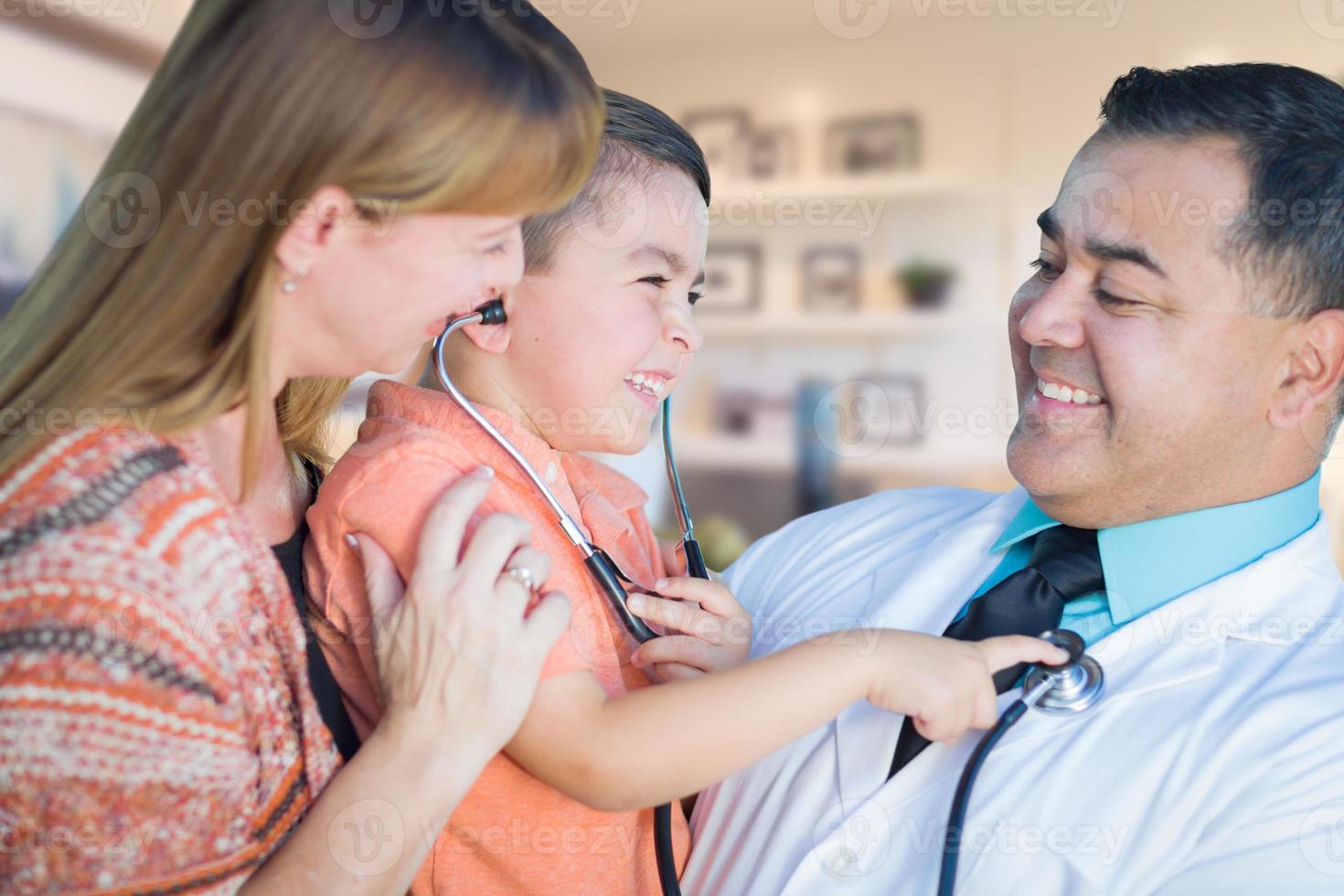 Young Boy and Mother Visiting with Hispanic Doctor in Office photo