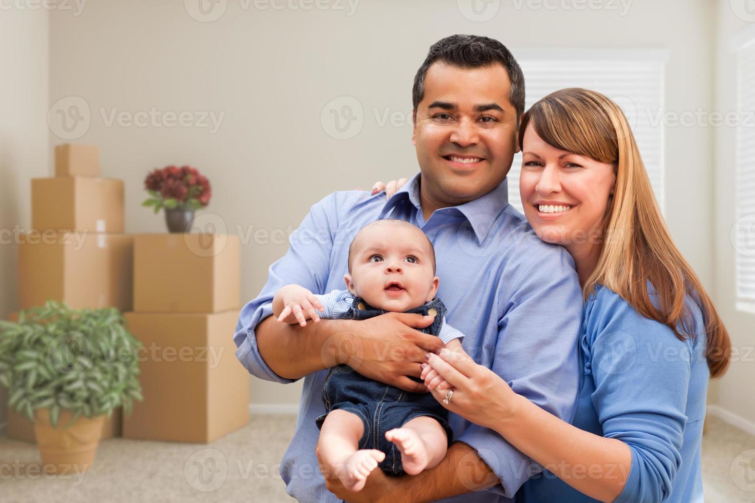 Mixed Race Family with Baby in Room with Packed Moving Boxes photo