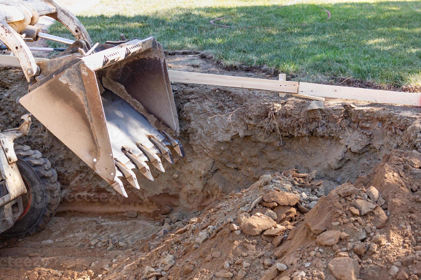 Small Bulldozer Digging In Yard For Pool Installation photo