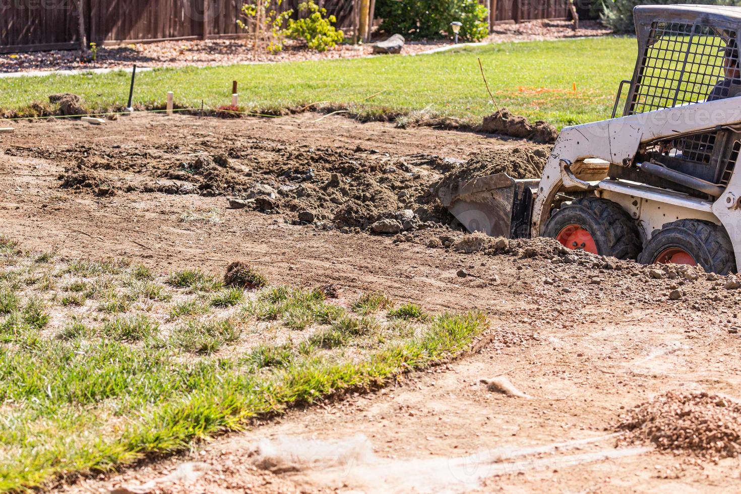 Small Bulldozer Digging In Yard For Pool Installation photo