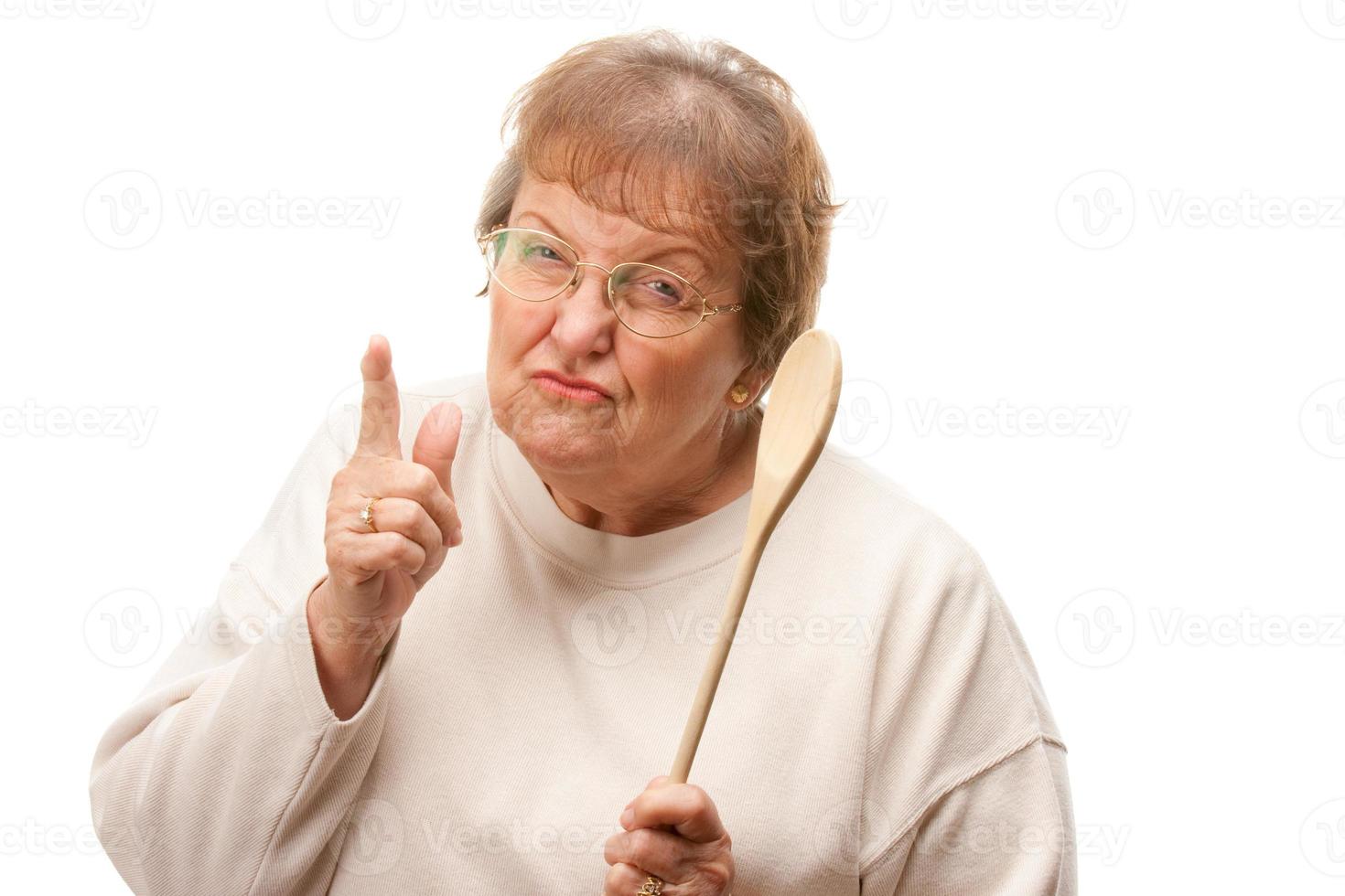 mujer mayor molesta con la cuchara de madera foto