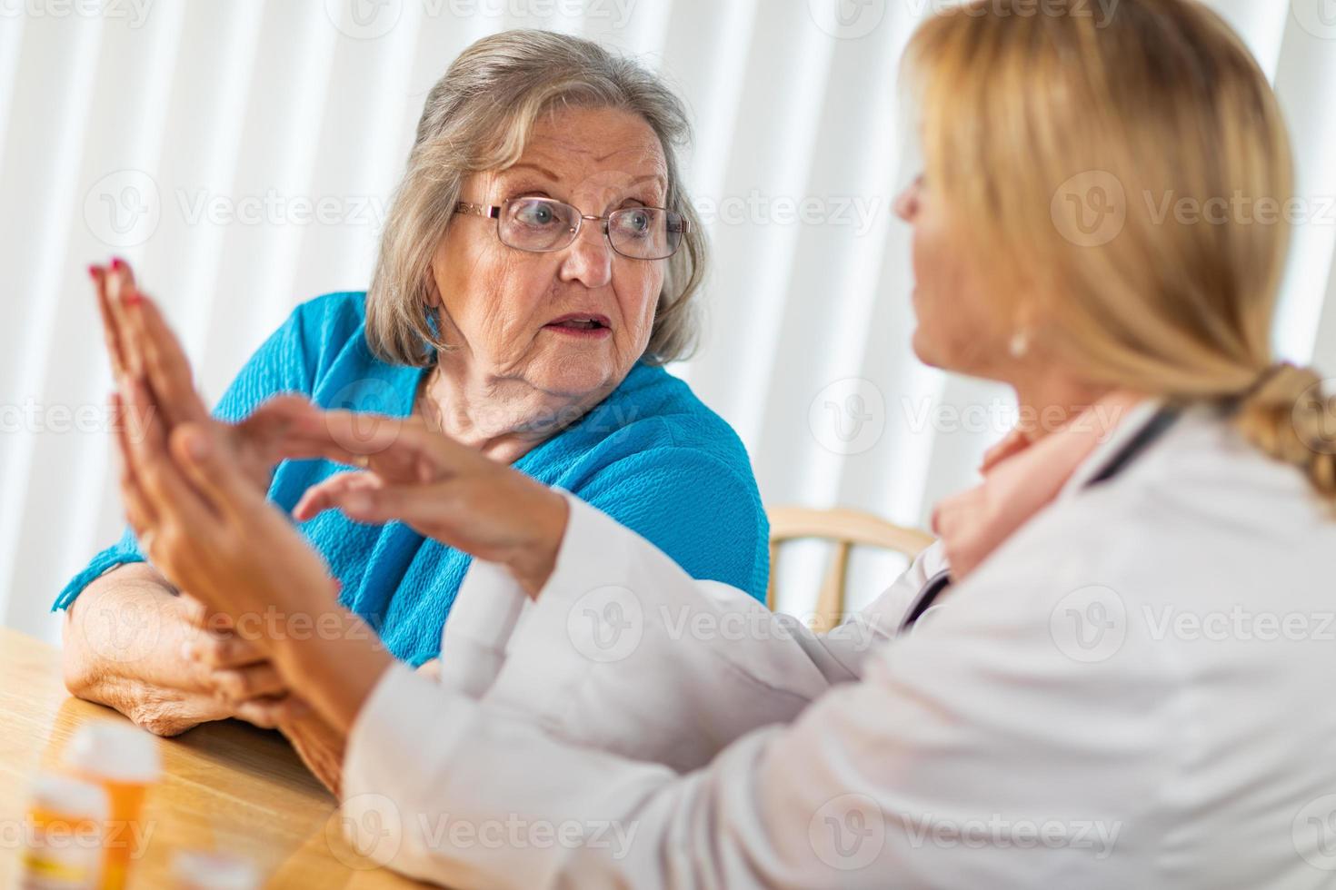 Female Doctor Talking with Senior Adult Woman About Hand Therapy photo