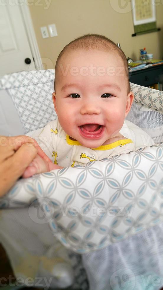 Adorable Chinese and Caucasian Baby Boy Playing In His Crib. photo