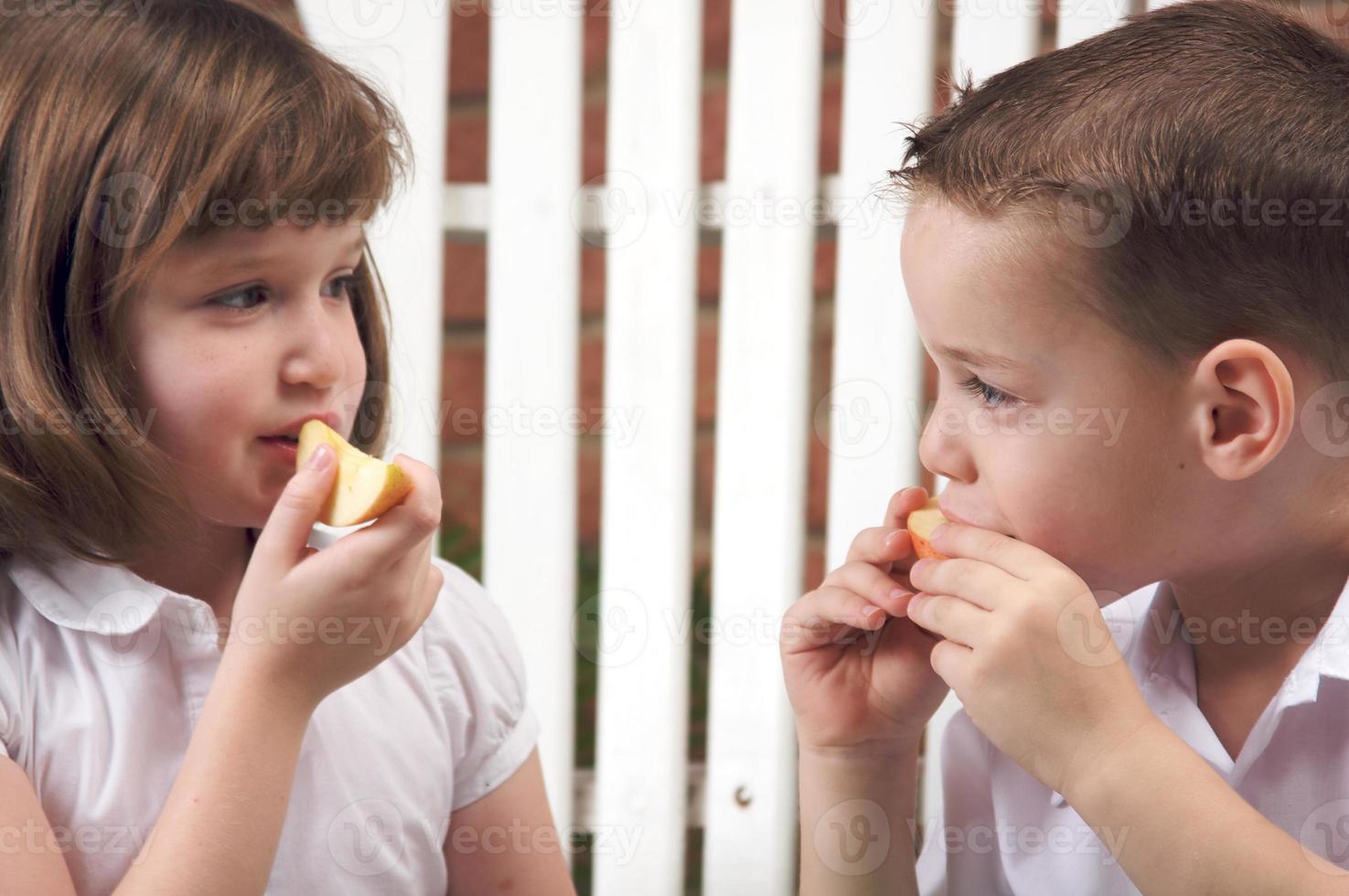 hermana y hermano comiendo una manzana foto