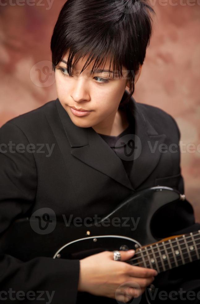 chica multiétnica posa con guitarra eléctrica foto