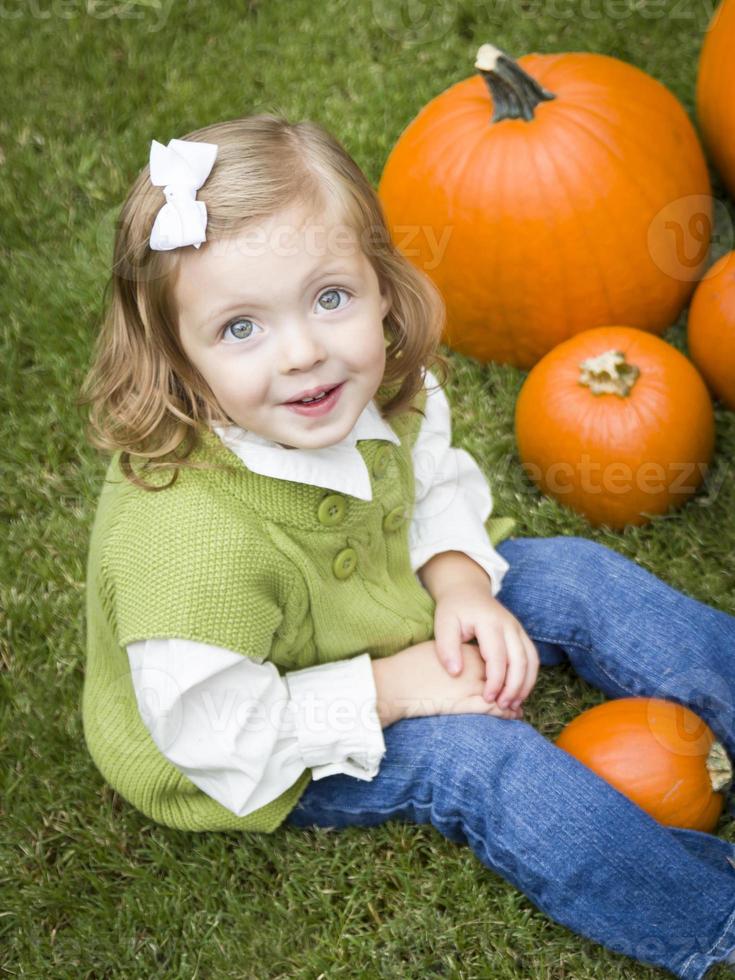 Cute Young Child Girl Enjoying the Pumpkin Patch. photo