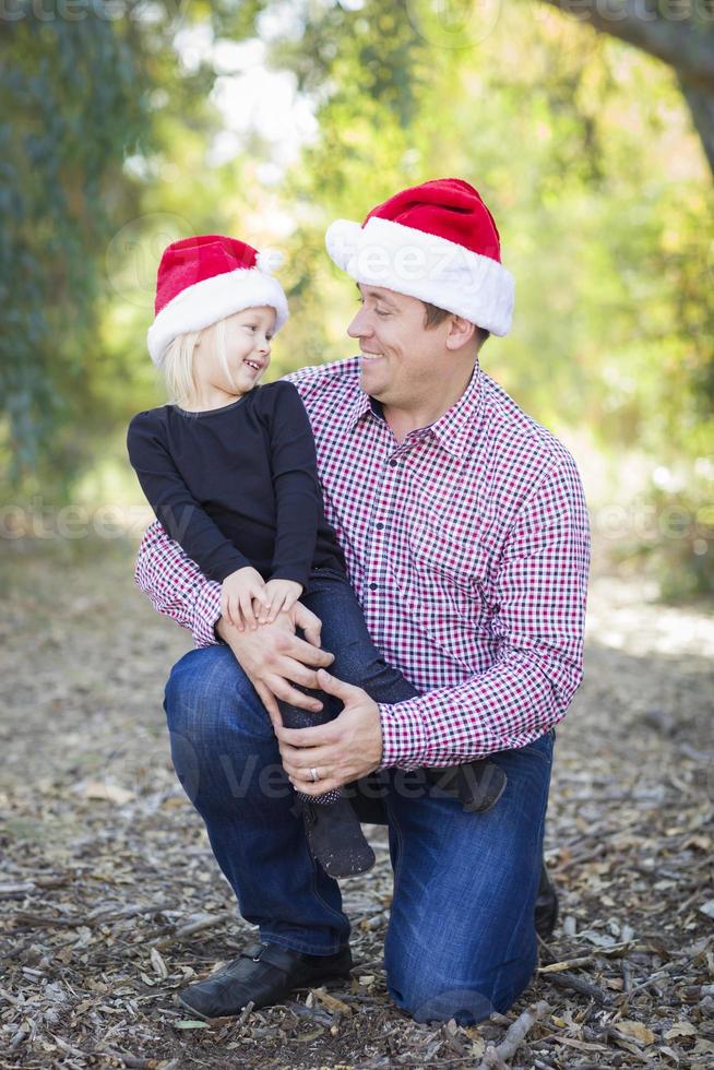 Portrait of Father and Daughter Wearing Santa Hats photo