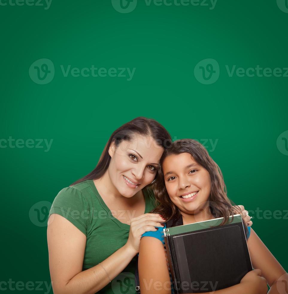 pizarra en blanco detrás de la orgullosa estudiante hispana de madre e hija foto