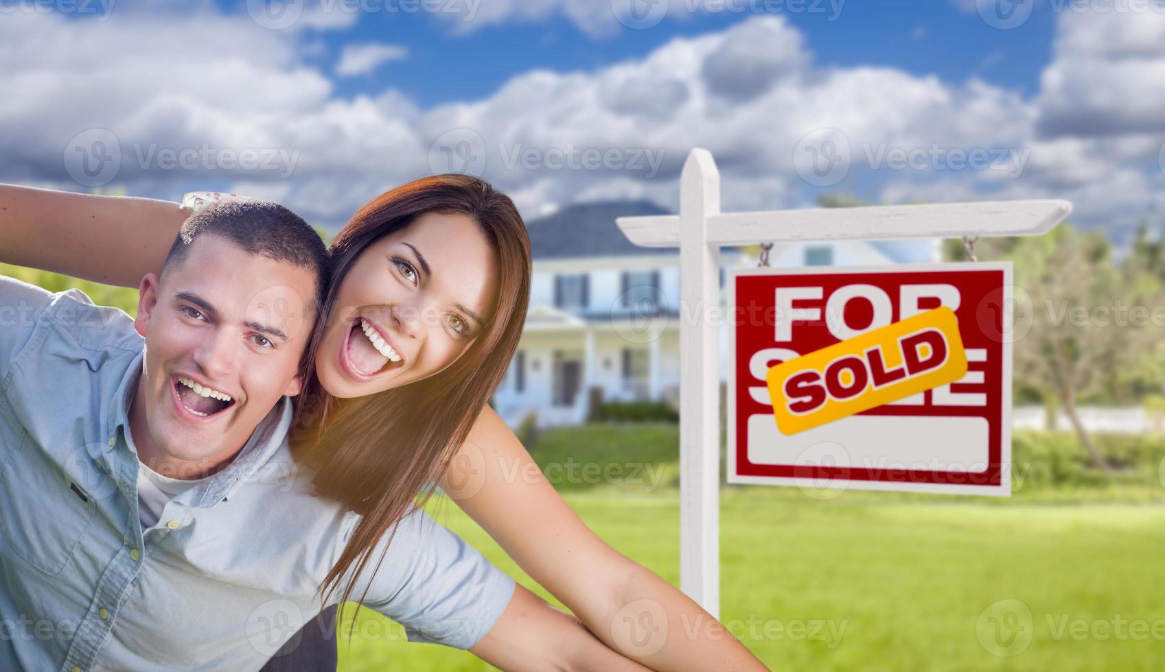 pareja militar frente a casa con cartel vendido foto