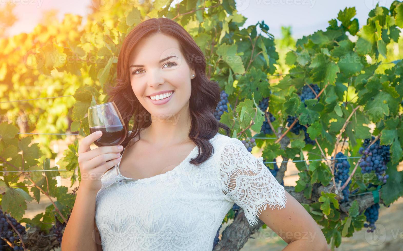 Beautiful Young Adult Woman Enjoying Glass of Wine Tasting In The Vineyard photo